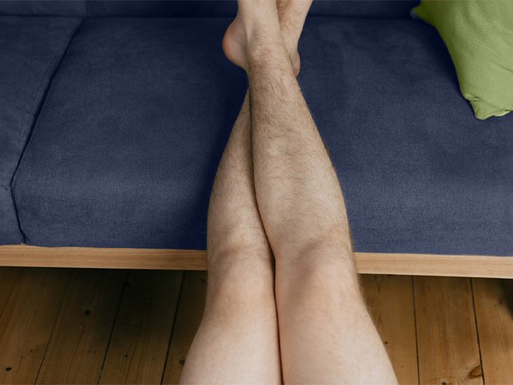 A man rests his legs on a cushion