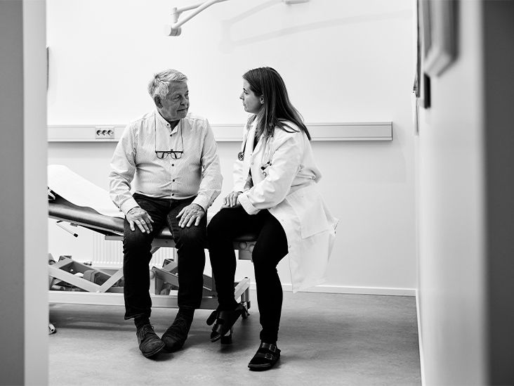 An older man talks with a female doctor