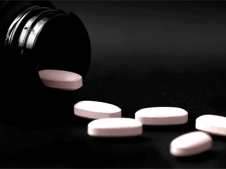 Statins tablets spill out of a jar