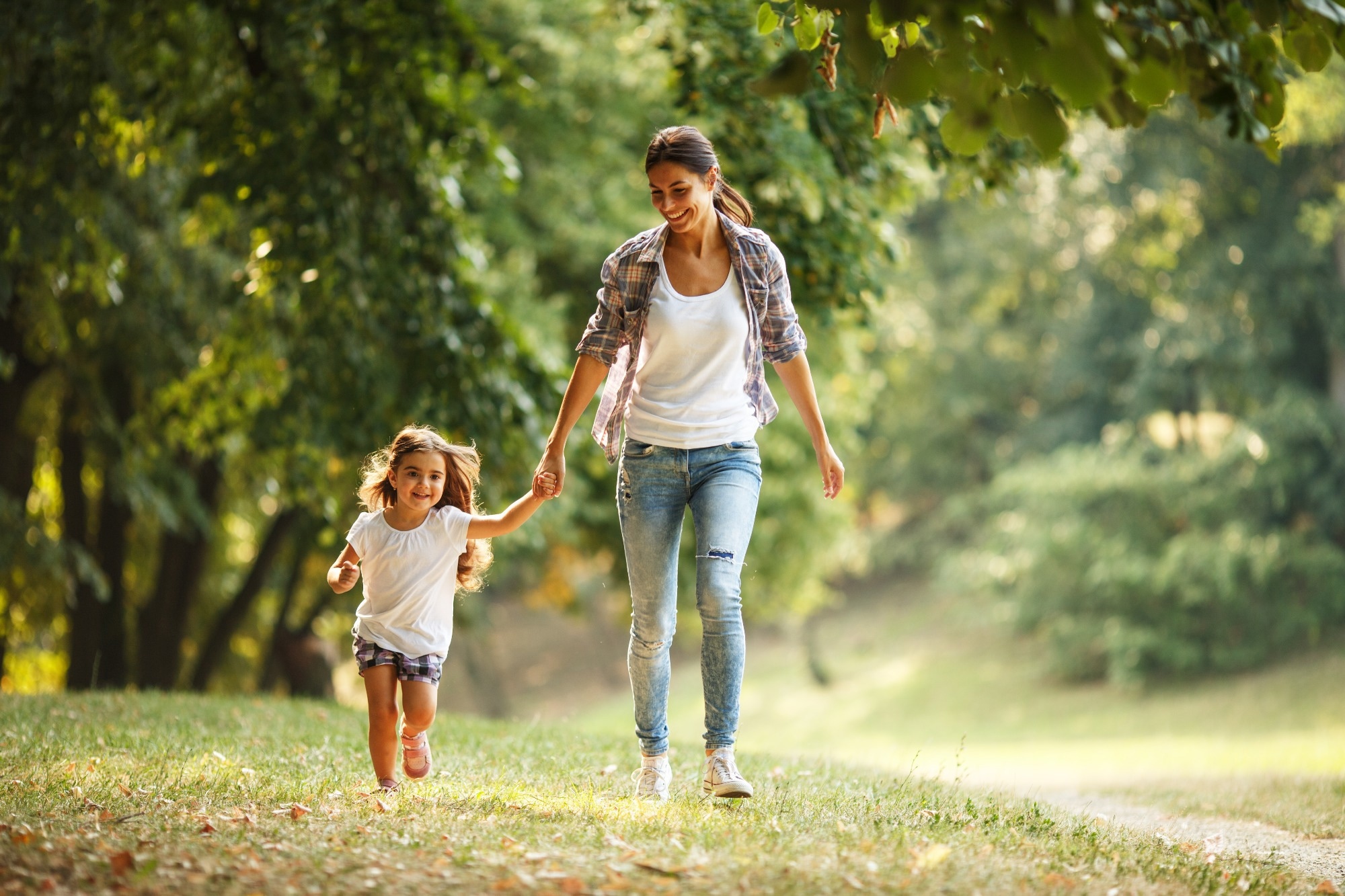 Woman and child walk in a park