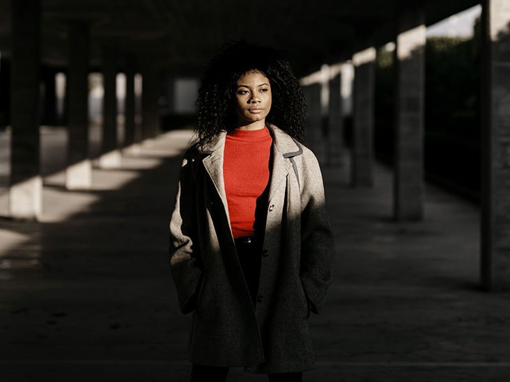A younger African-American woman strolls along an underpass
