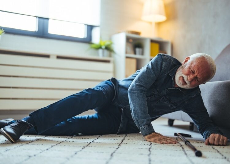 Disabled Senior Man Lying On Carpet
