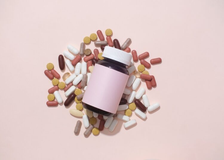 Pills of different colors and shapes are mixed.