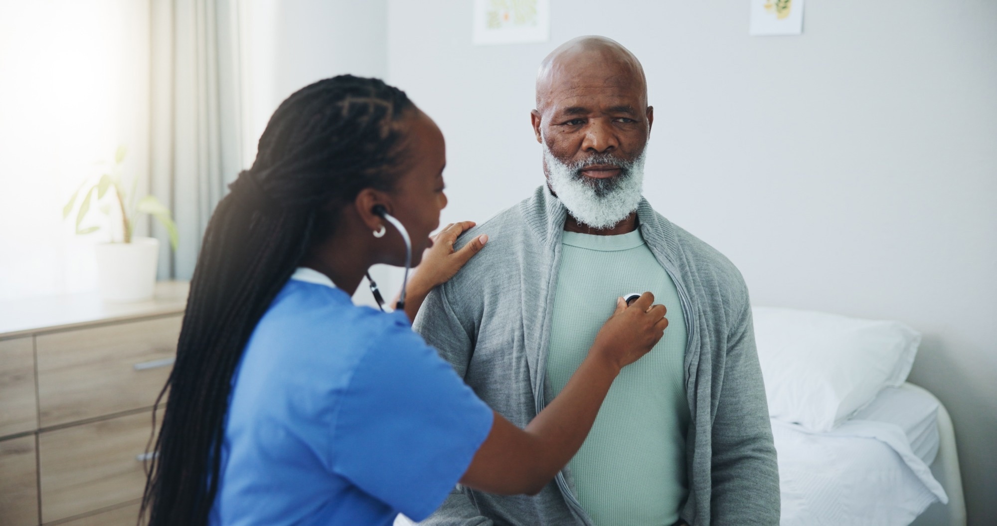 Senior, man and nurse with listening on stethoscope for heartbeat assessment or cardiovascular health on bed.
