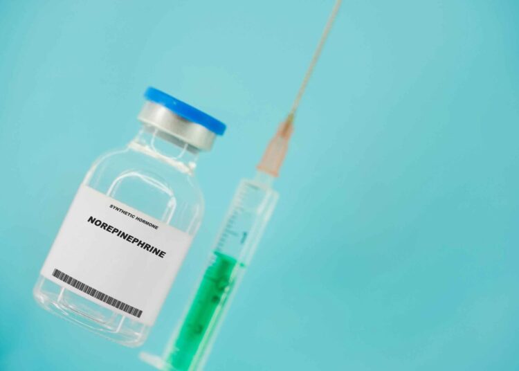 a bottle of norepinephrine with a syringe