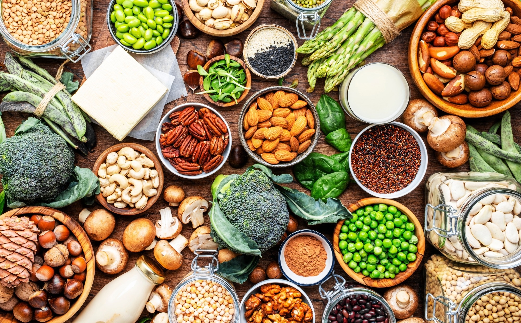 Full set of plant based vegetarian food ingredients: legumes, beans, nuts, soy and almond milk, tofu, quinoa, vegetables, seeds and sprouts
