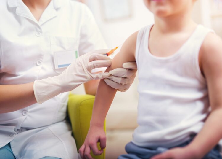 Pediatrician makes vaccination to small boy