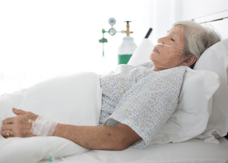 Elderly patient wear oxygen cannula in hospital bed