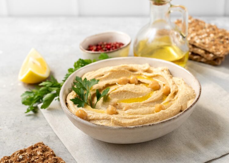 Fresh hummus with chickpea olive oil and lemon with multigrain crackers