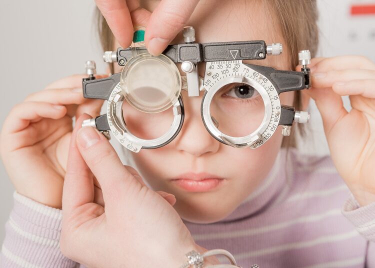 young girl smiling while undergoing eye test