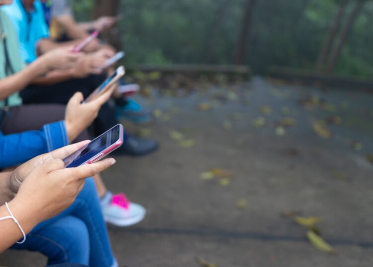 Group of friends watching smart mobile phones
