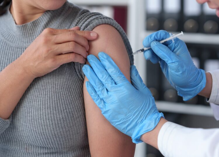 woman receives flu vaccine at hospital