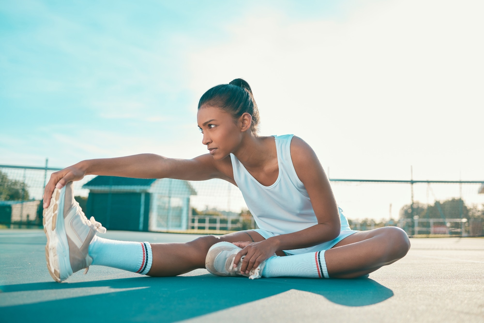 Tennis player, girl and stretching for fitness on court with leg warm up, getting ready and match practice.