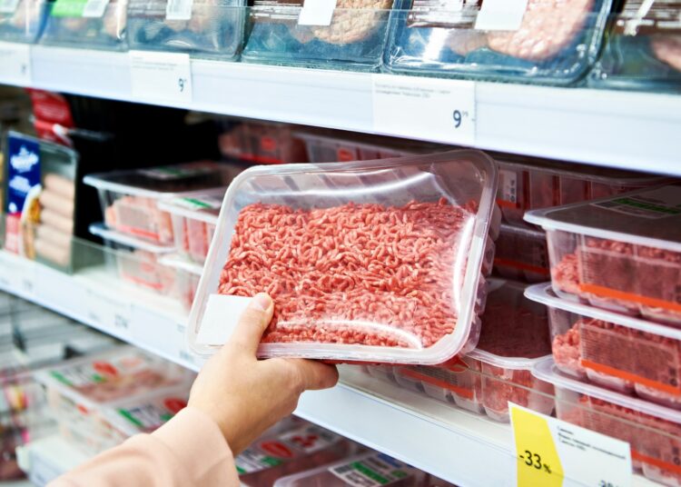 Minced meat in the hands of the buyer in the store