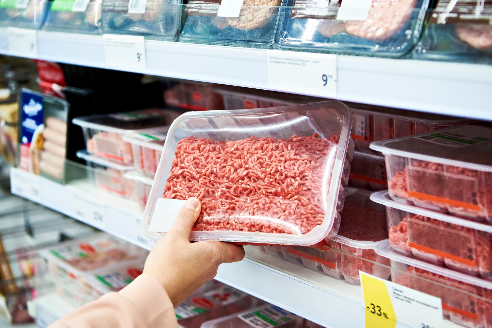 Minced meat in the hands of the buyer in the store