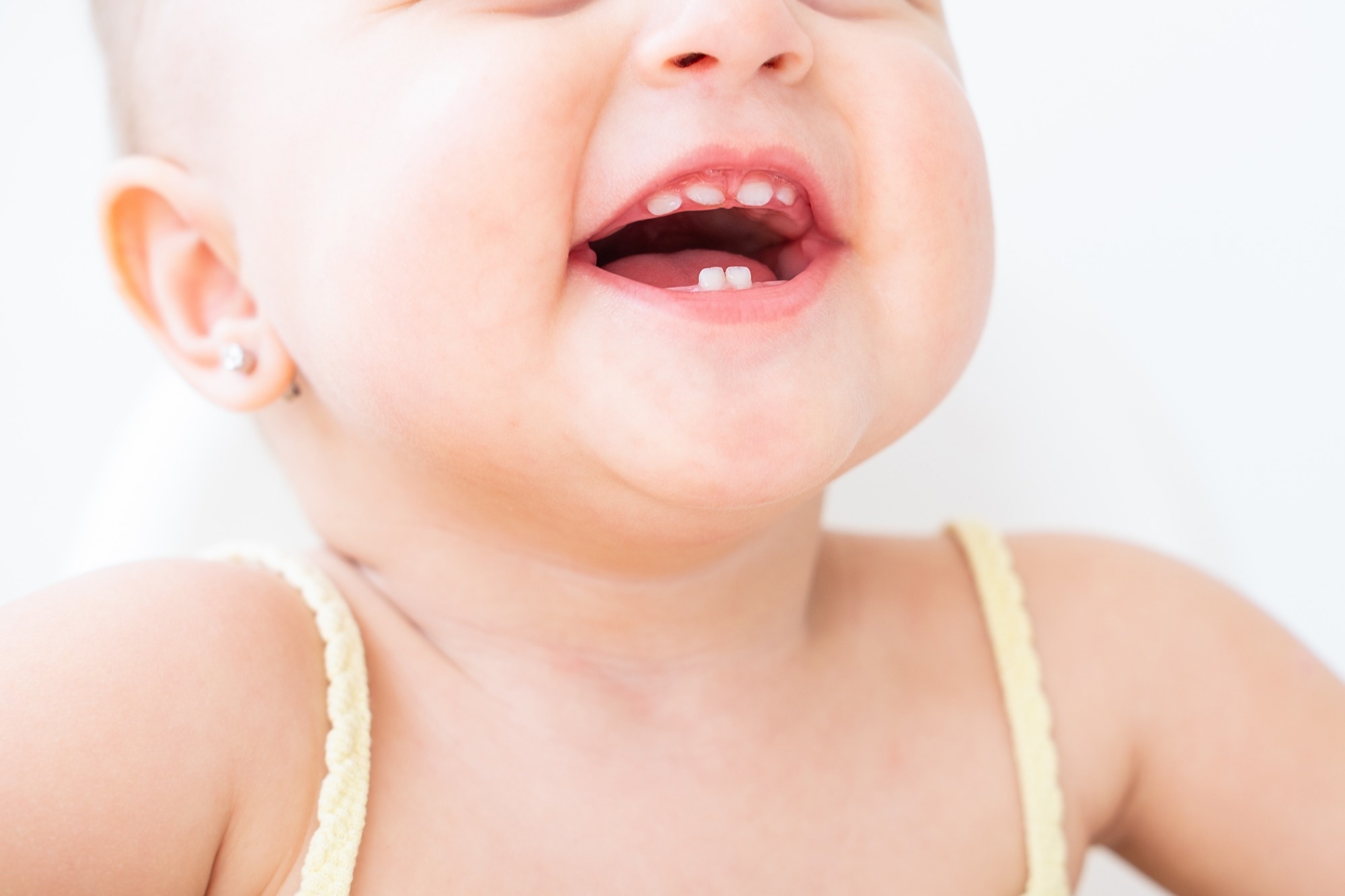 close up baby girl smiling with first teeth
