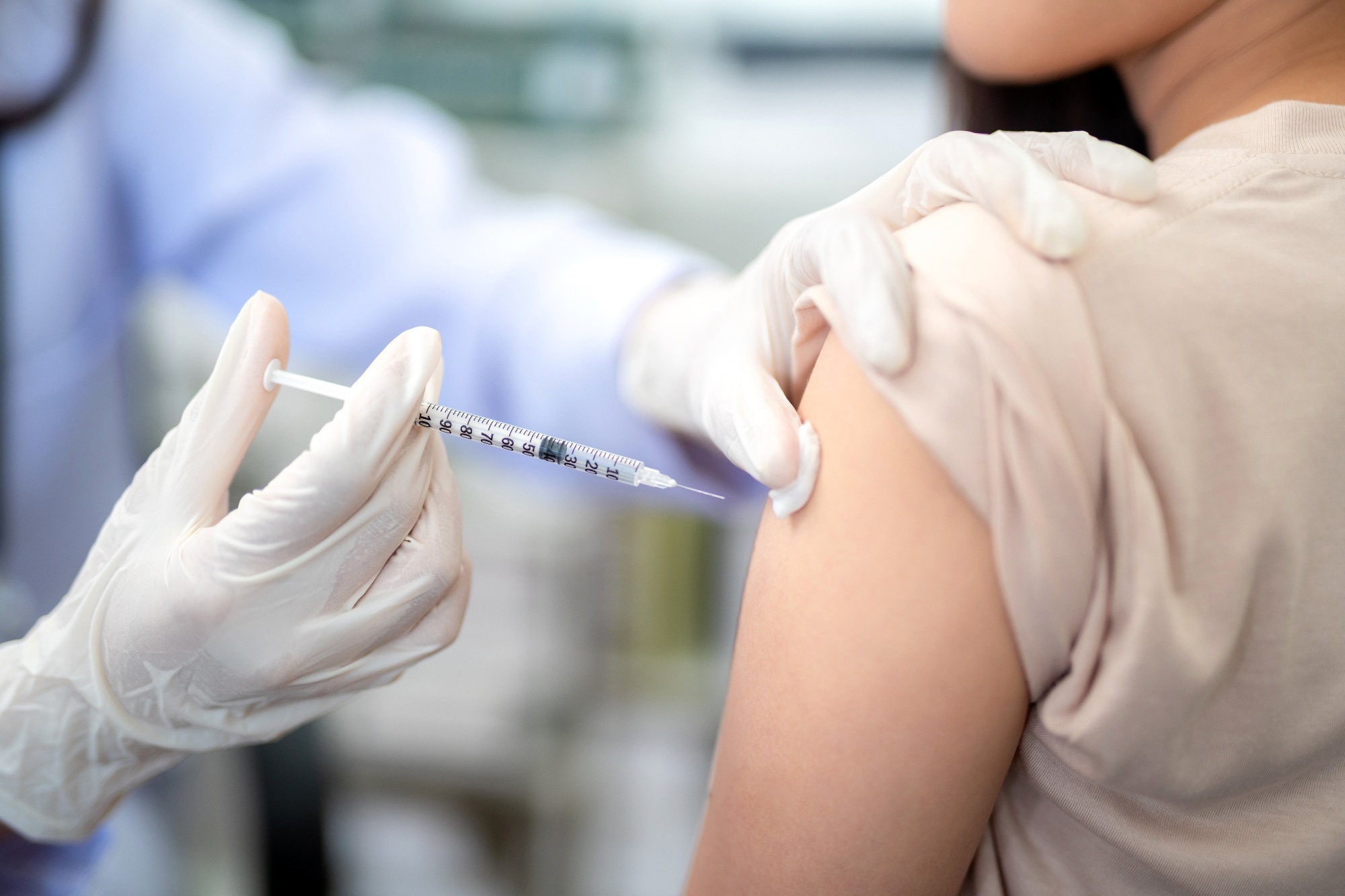 Close up of doctor making a vaccination in the shoulder of patient. coronavirus