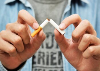 Close up of mans hands snapping a cigarette