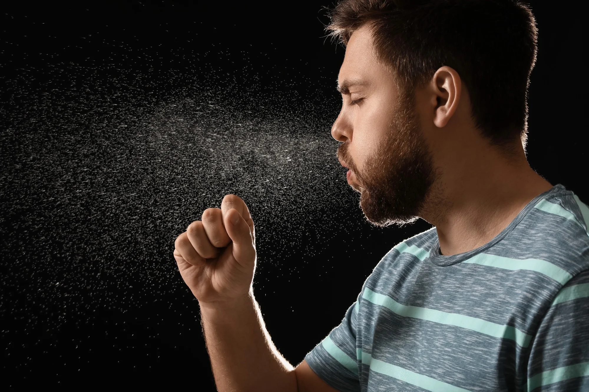 Coughing man on dark background.