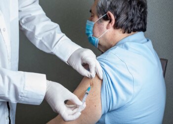 Antivirus vaccination for older people in clinic. General practitioner vaccinating an elderly patient against flu, influenza, pneumonia or coronavirus.
