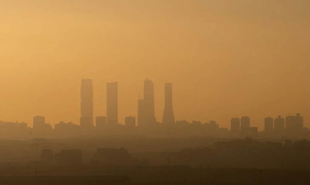 Madrid Business Area skyscrapers with air pollution during sunset. Image Credit: Marcos del Mazo / Shutterstock. Study: Air pollution implies unequal threats to adverse birth outcomes across maternal educational levels in Madrid, Spain