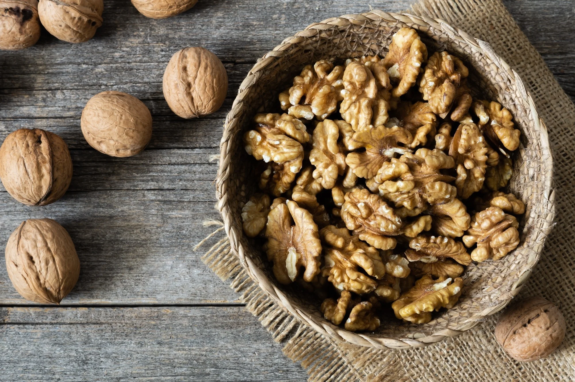 Bowl of walnuts next to unshelled walnuts